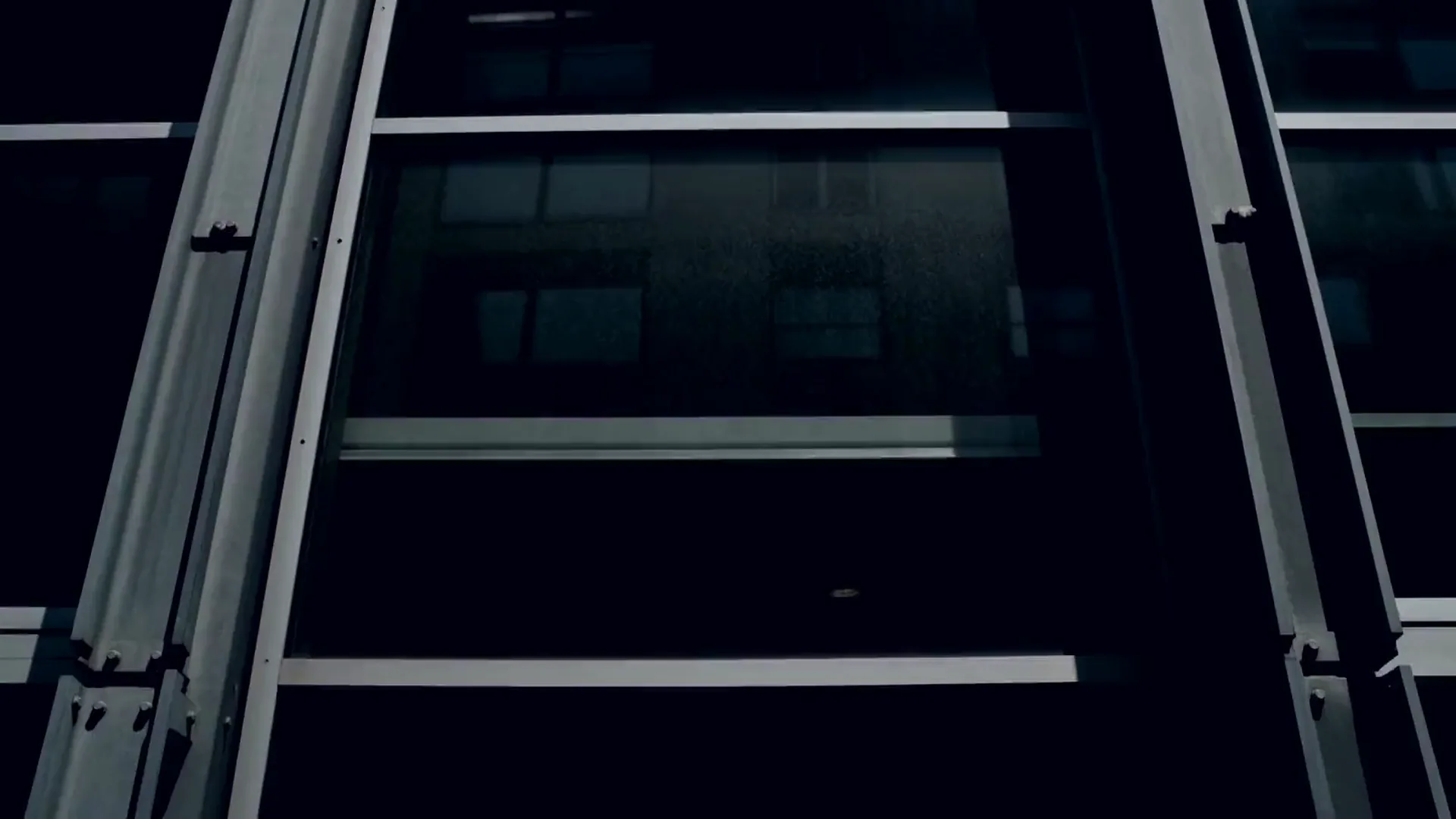 Looking up a glass office facade where freshly cleaned panes mirror the sky and clouds